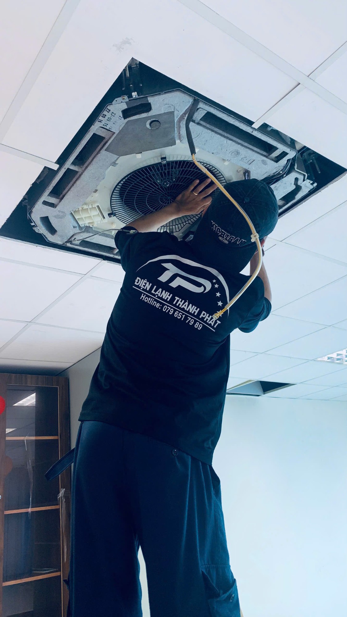 Kỹ thuật viên kiểm tra hệ thống điện và board máy lạnh trong quá trình sửa chữa tại Phú Nhuận.